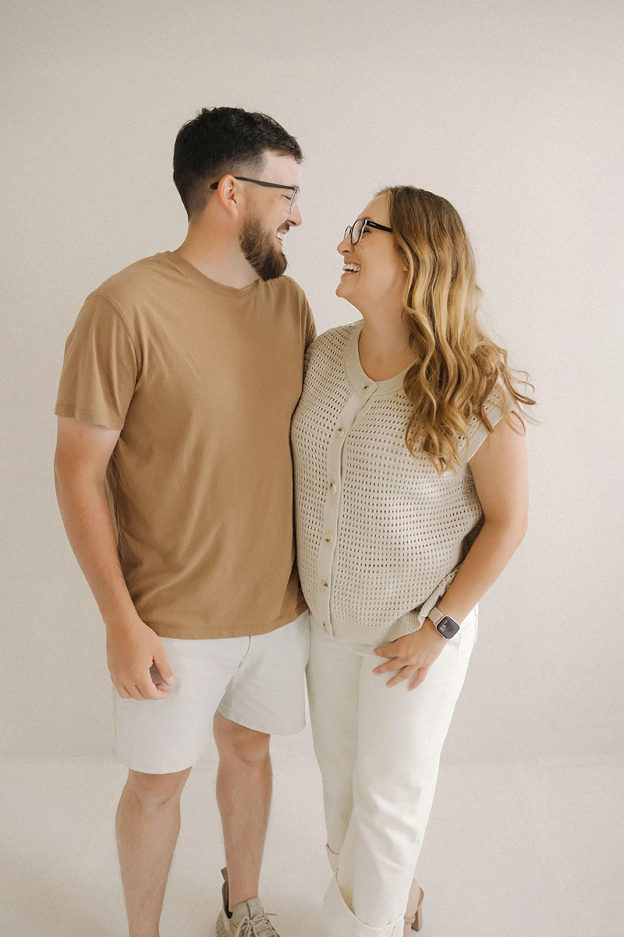 A joyful couple sharing a candid moment together during their Studio Loft 18 family photos, captured in a warm, modern studio setting with natural, timeless styling.