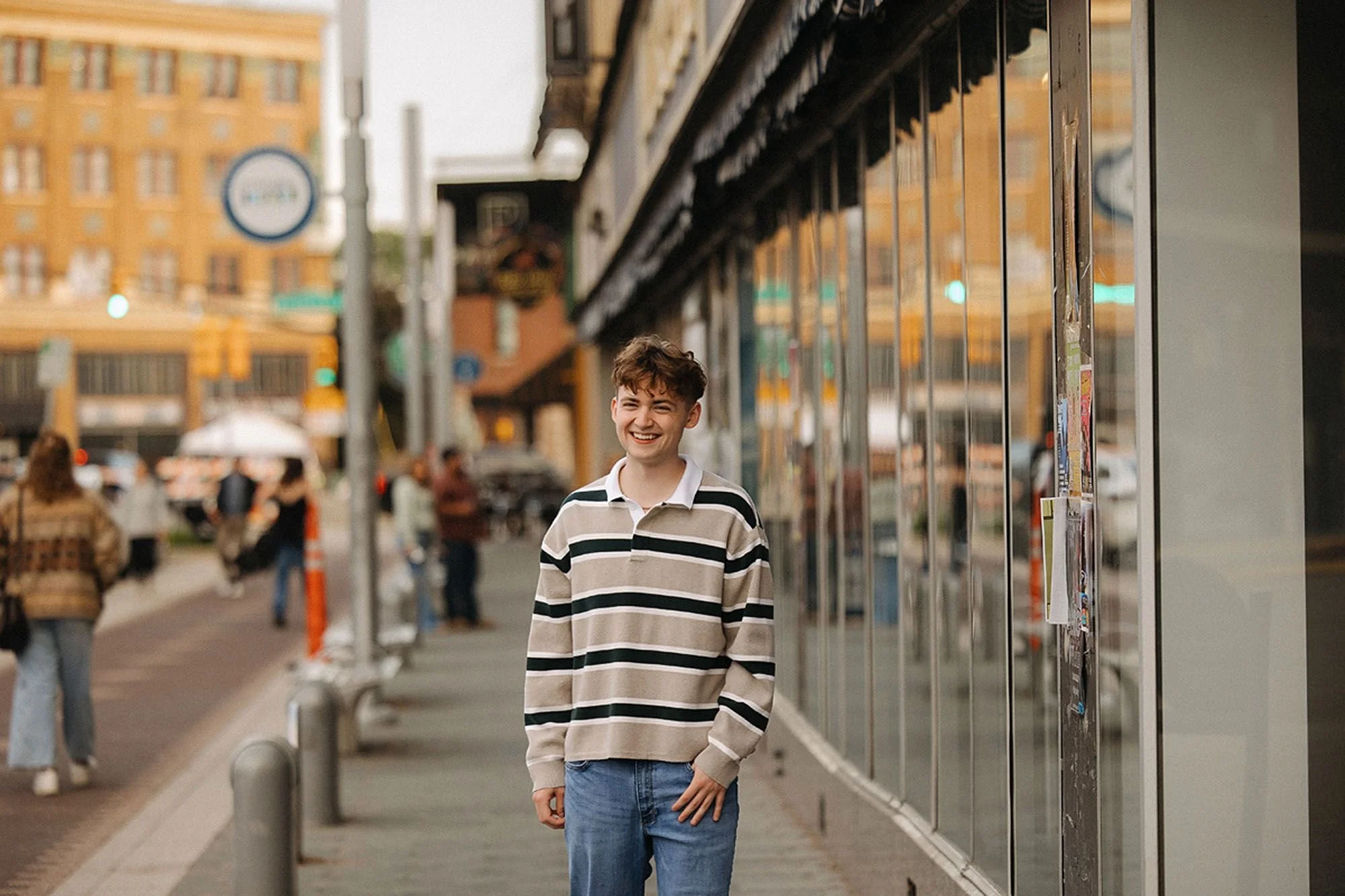 Smiling senior walking through downtown Sheridan during a relaxed urban senior photo session with city streets and storefronts in the background