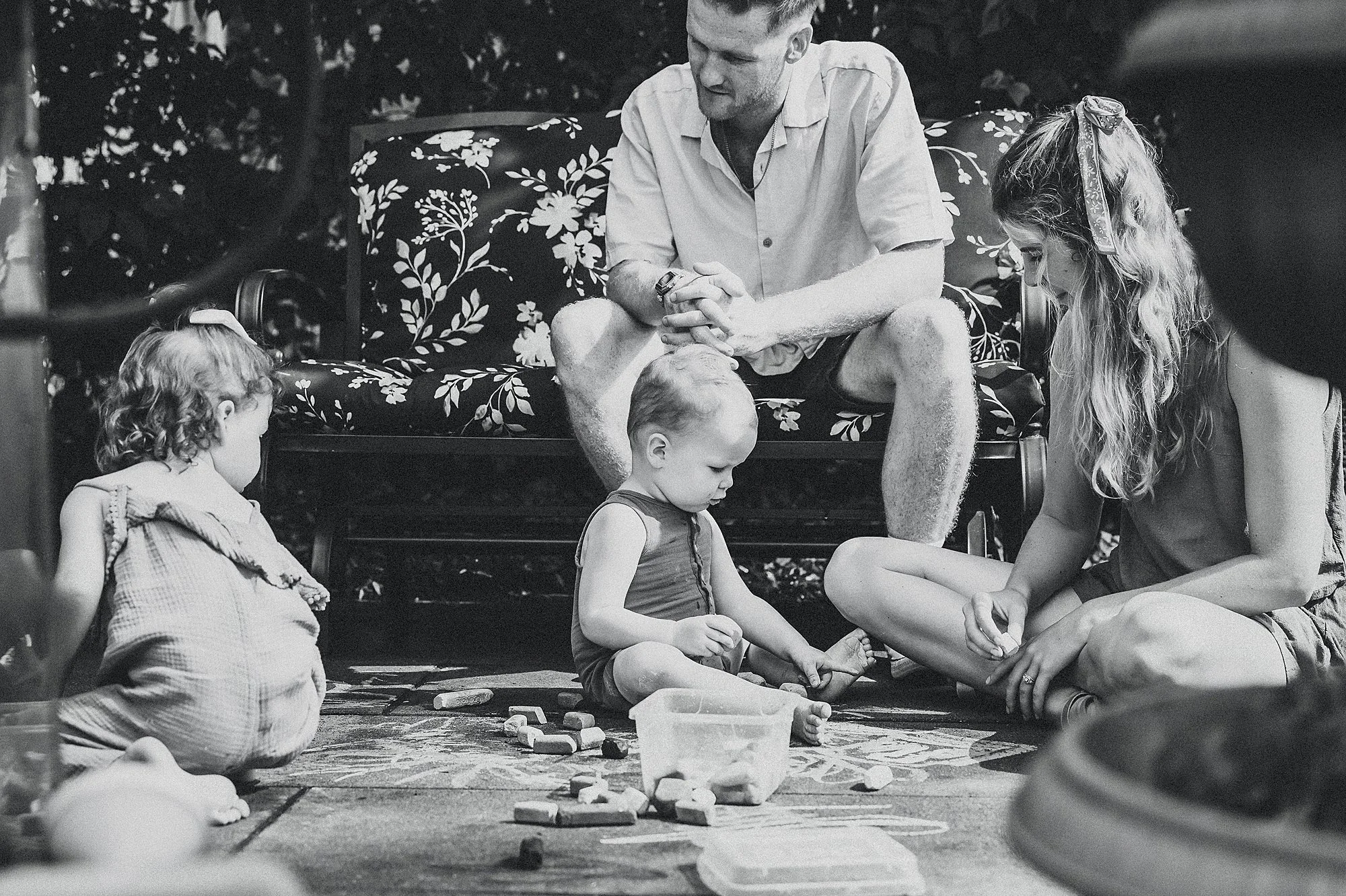 A family plays together in their backyard during a photography session in Indianapolis, Indiana, capturing happy moments