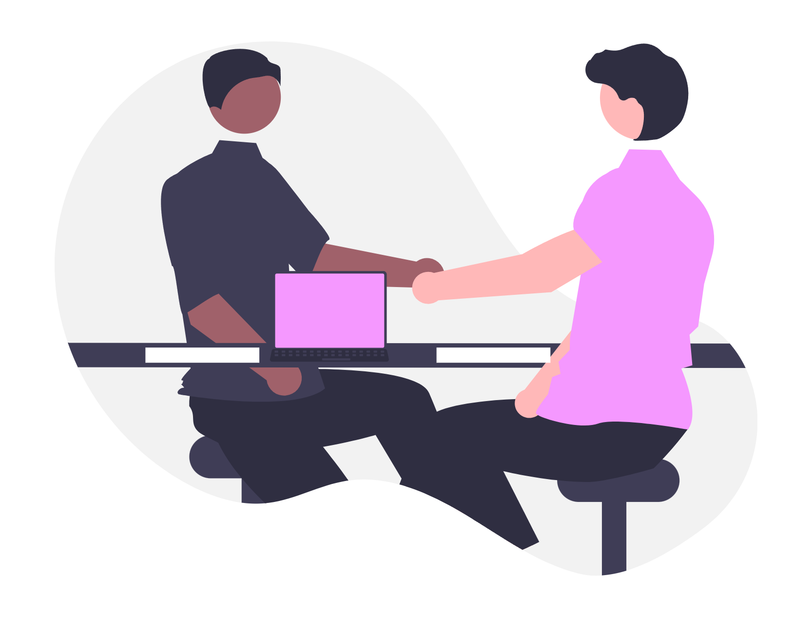 Two people shaking hands in an office setting, with a laptop and books on a desk.