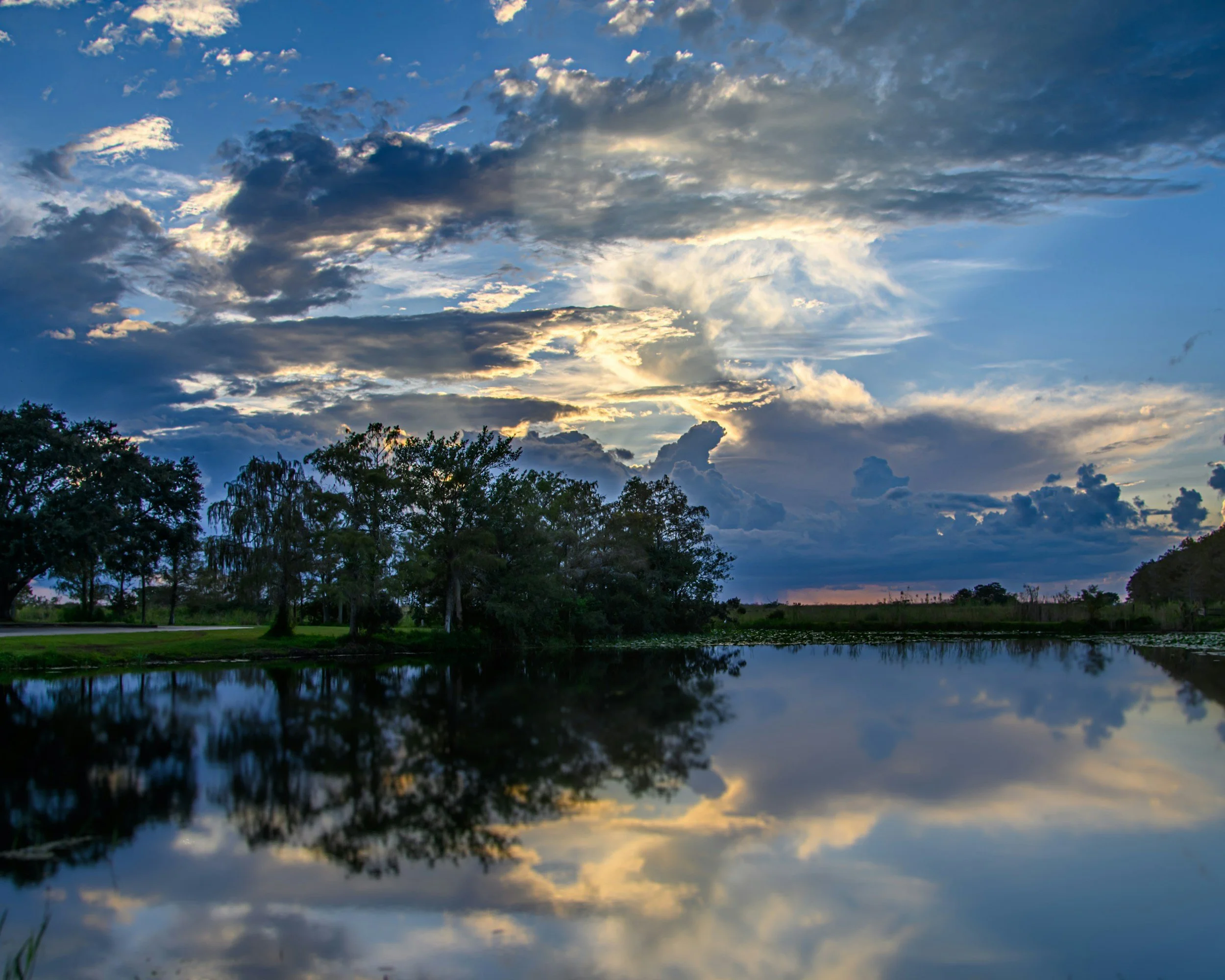 Beautiful sunset over a Florida lake with trees and clouds.