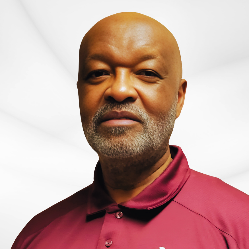 Close-up of a middle-aged African American man with a bald head and gray beard, wearing a maroon collared shirt, against a white background.
