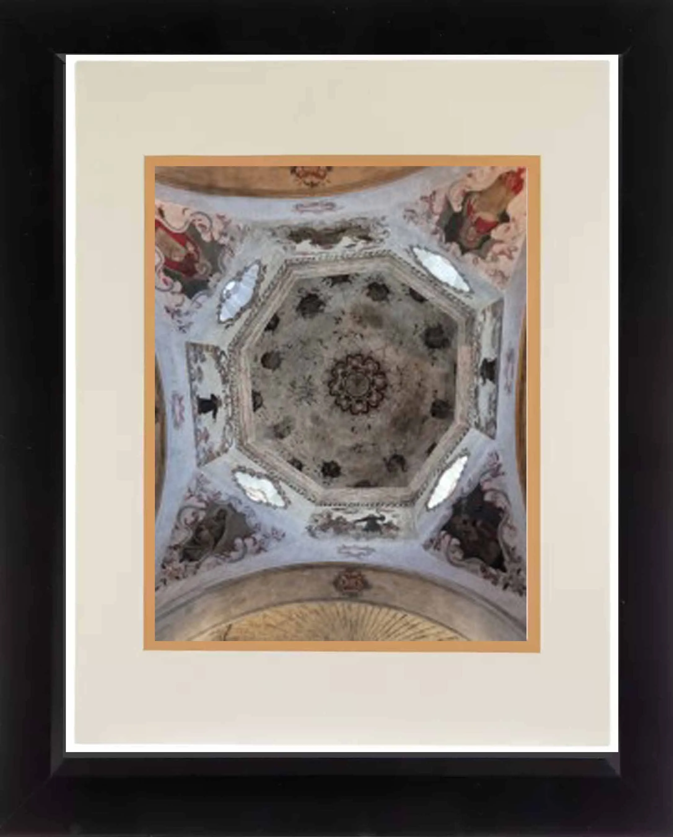 A photograph of an ornate, painted ceiling within a frame, showing intricate floral and geometric patterns.