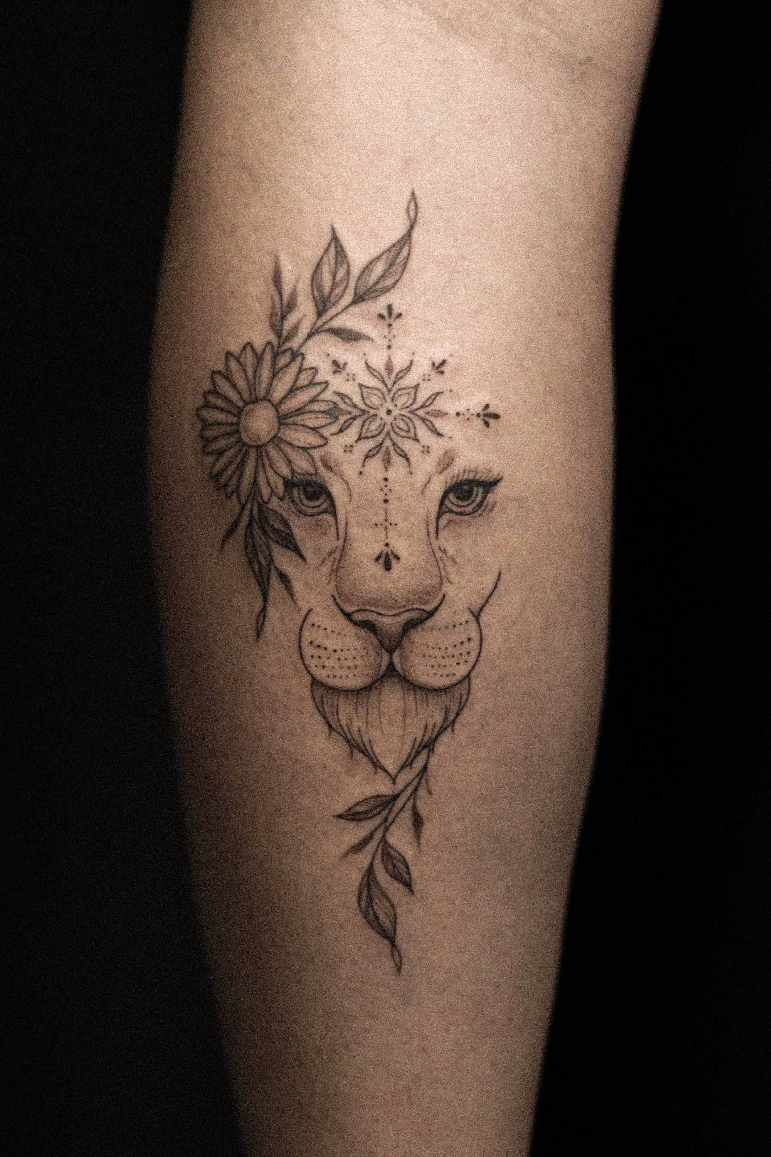 Tattoo van een cheeta met bloem- en bladmotieven op de voorarm.