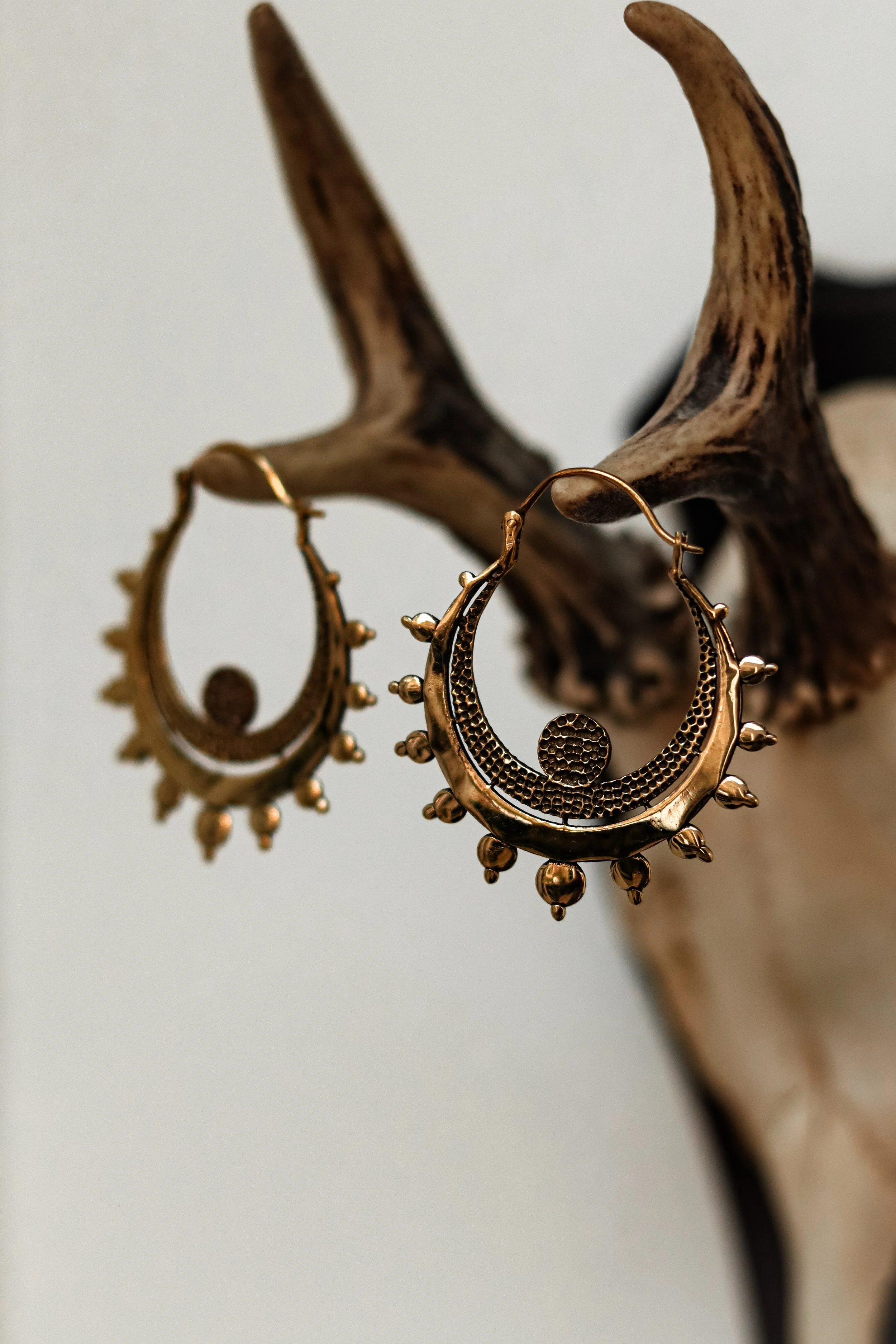 Gouden sieraden, oorbellen, hangen aan een tak van een gewei.