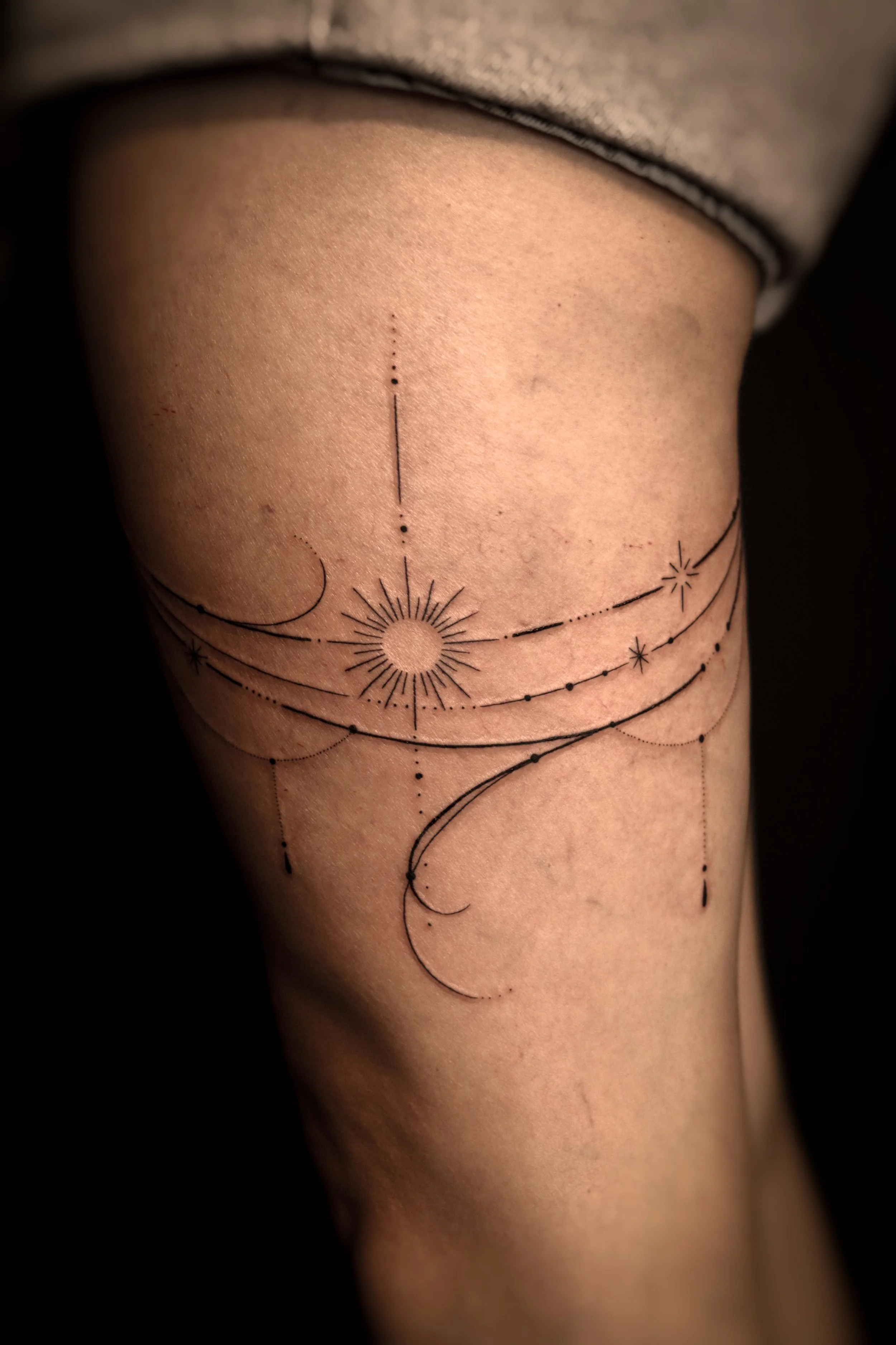 Tattoo met sterren en geometrische lijnen op de bovenarm.