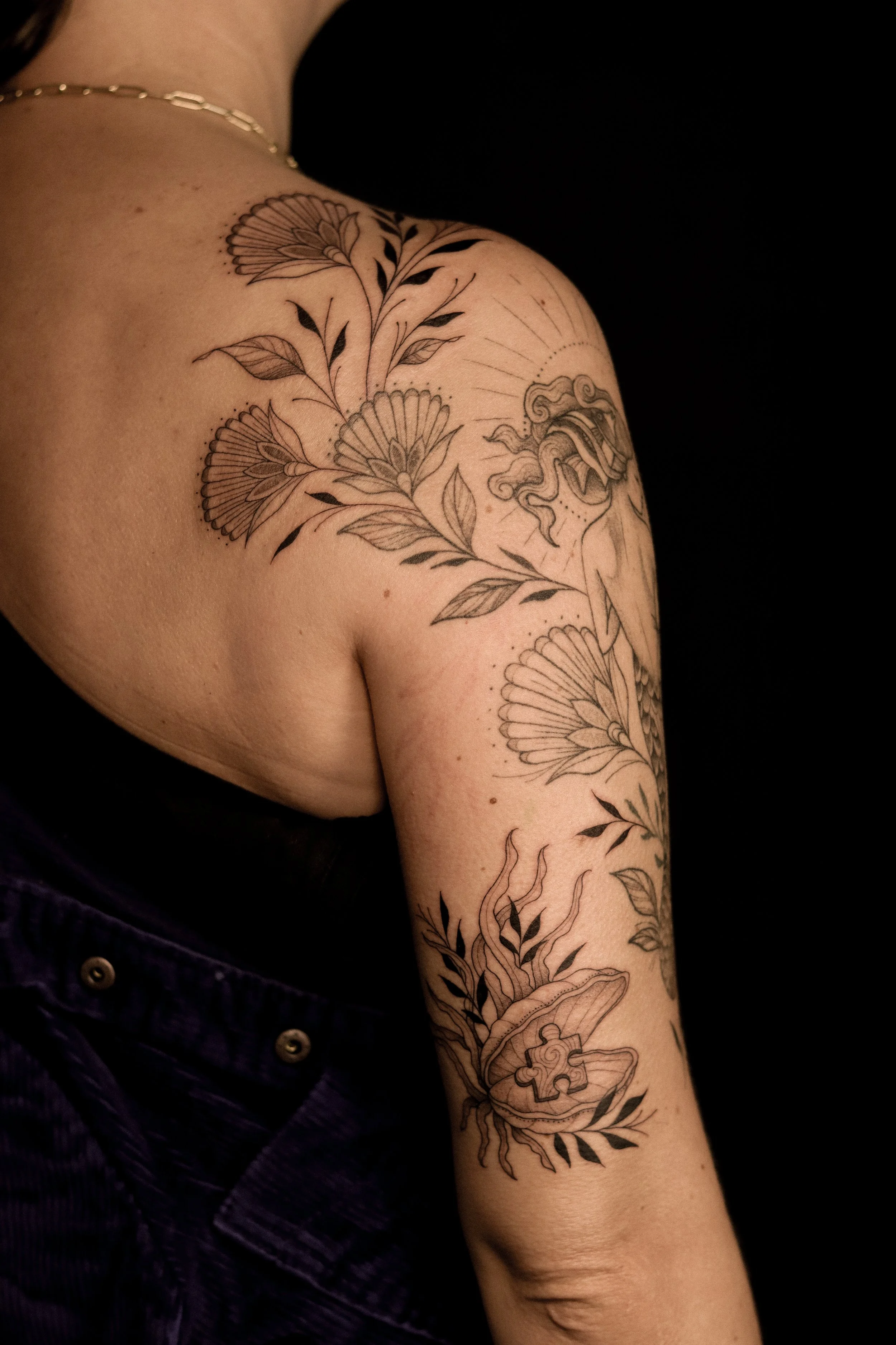 Tatoeage van bloemen en een prisma op de arm van een persoon.