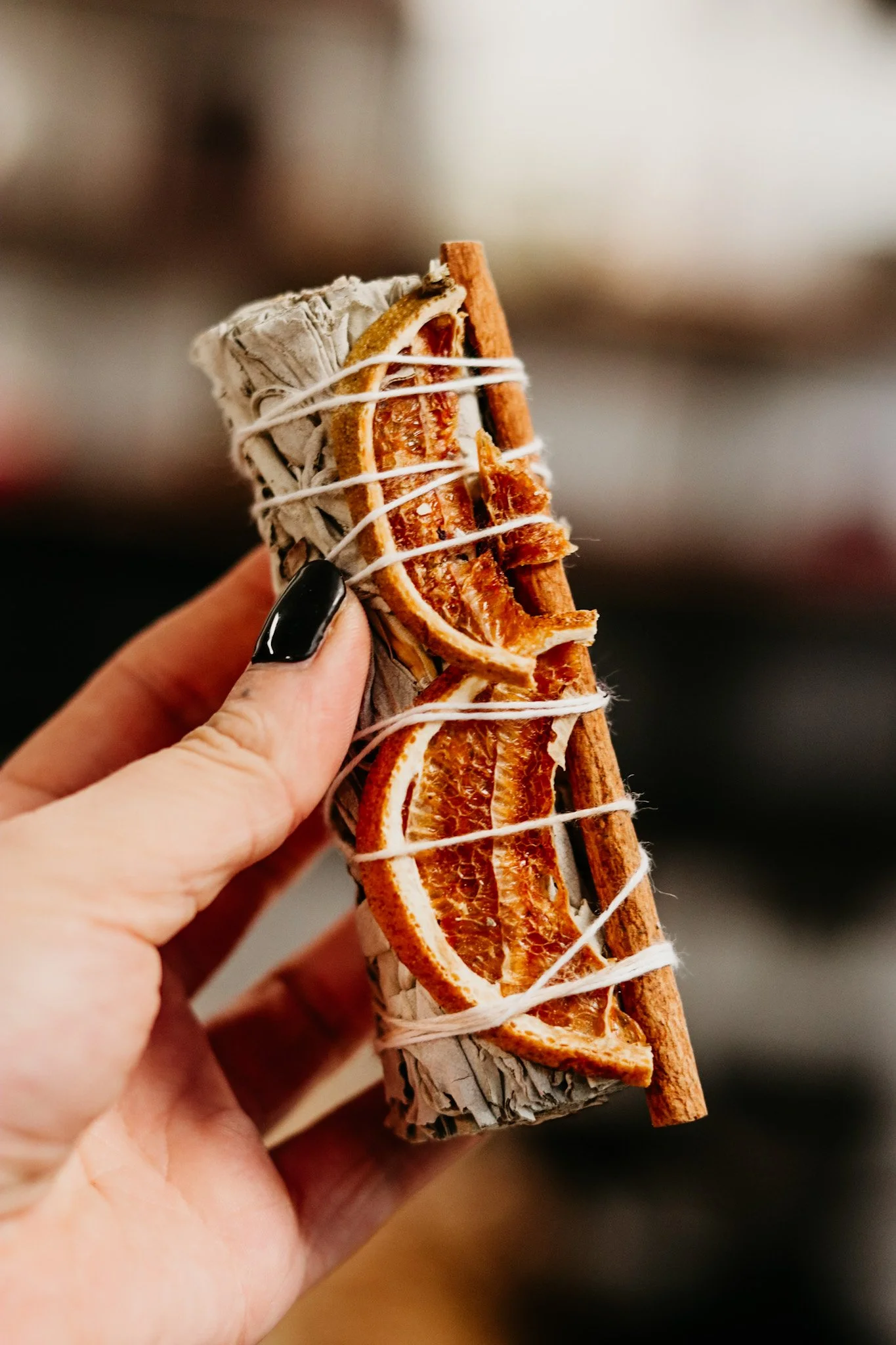 Hand die een pakket met gedroogde sinaasappelschijf en kaneelstok vasthoudt.