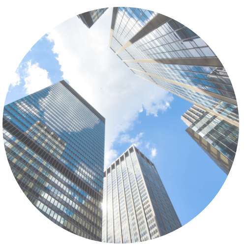 Korkeita lasitalo, katsottuna alaviistosta, taivaalla pilviä ja auringonvalo heijastuu ikkunoista.