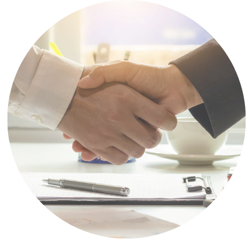 Kahden henkilön kätteilyssä pöydällä on paperi, kuulakärkikynä, magneetti ja kahvikuppi.