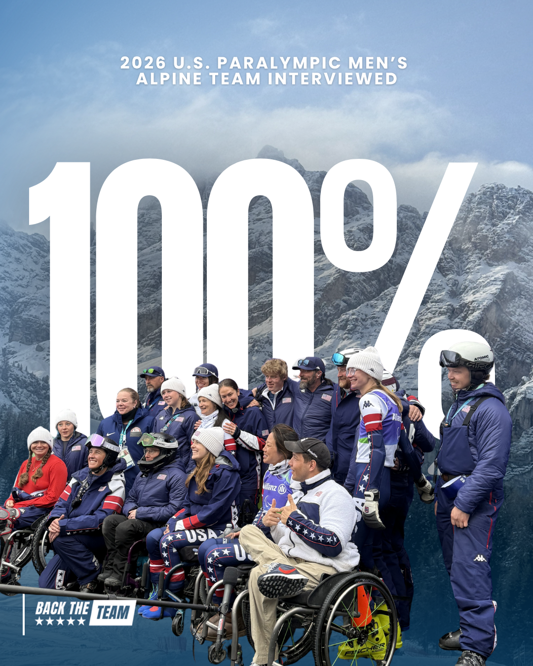 Group photo of the U.S. Paralympic men's alpine ski team with some members in wheelchairs, all dressed in navy and USA-themed uniforms, in front of snowy mountain scenery, celebrating their 100% interview record for the 2026 U.S. Paralympic Men's Alpine Team.