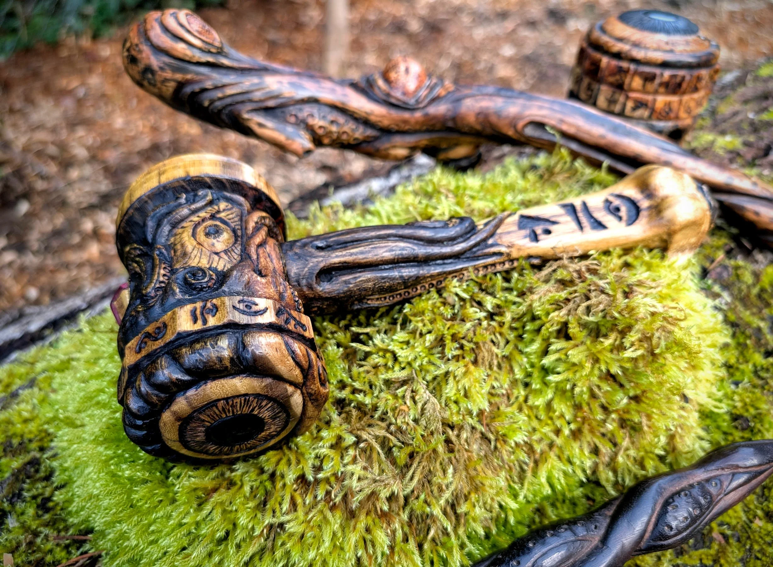 A selection of Eldritch Wood working items displayed upon a bed of moss on a large log.