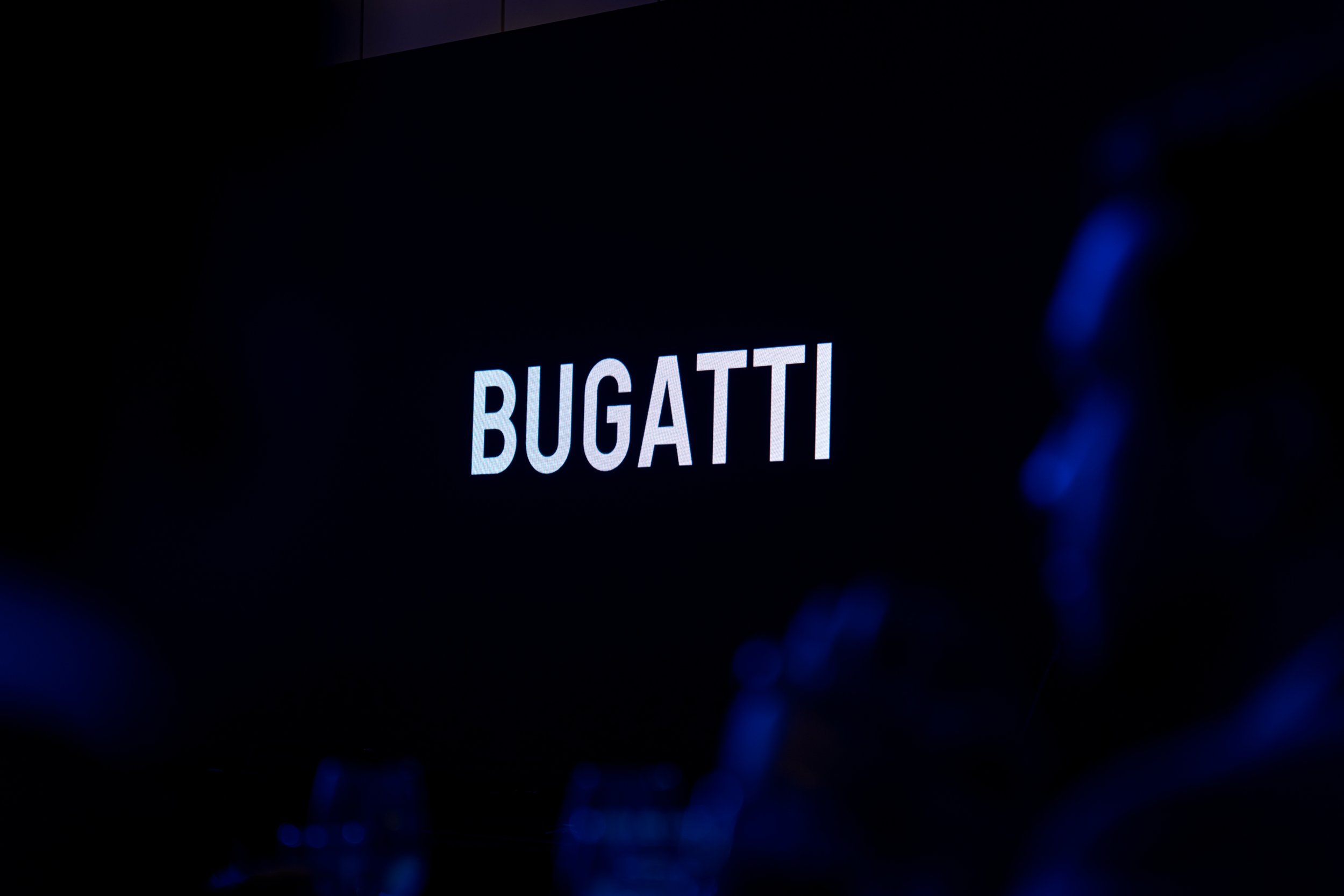The word 'BUGATTI' displayed on a dark screen.