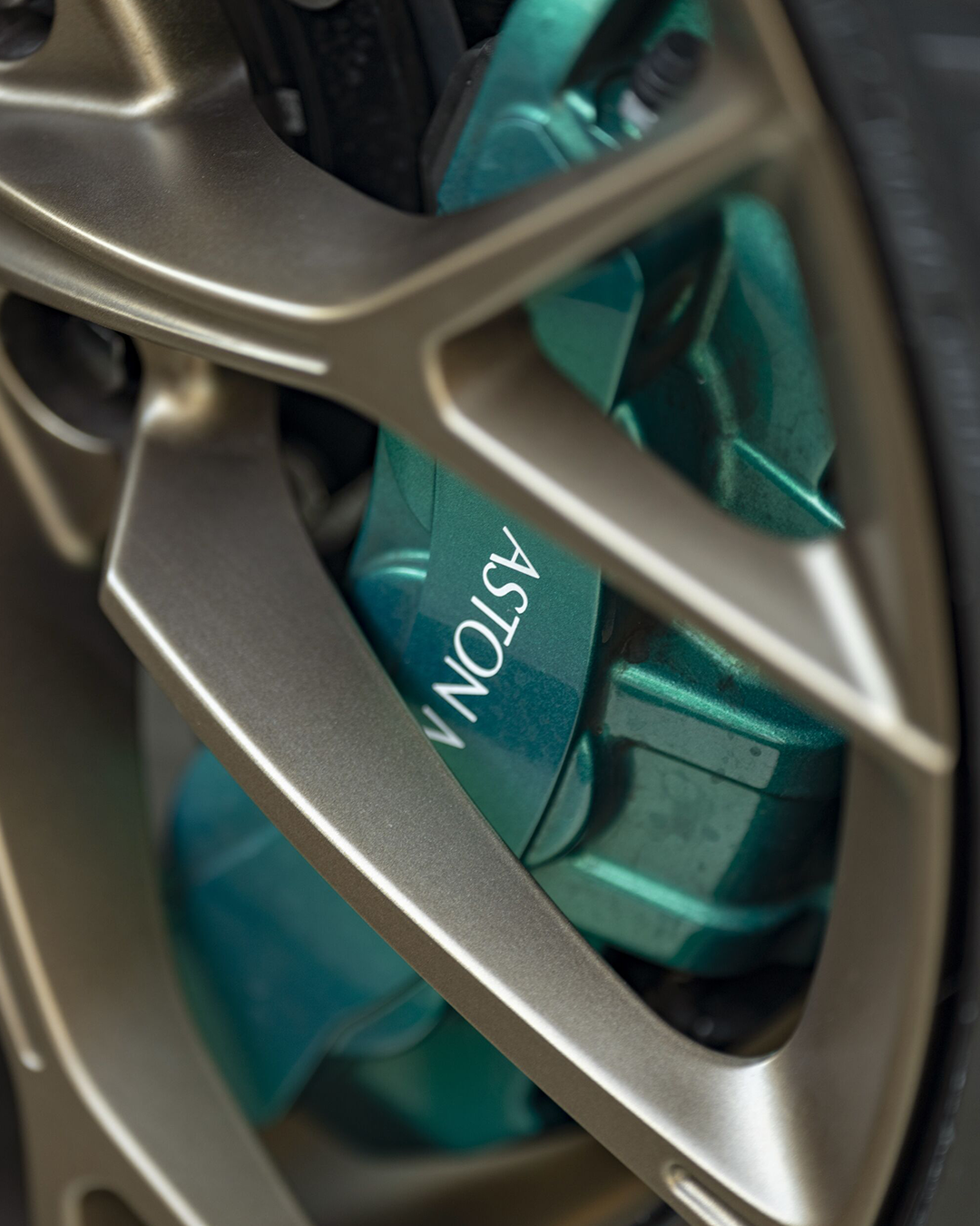A teal-colored power tool stored in a car's wheel rim.