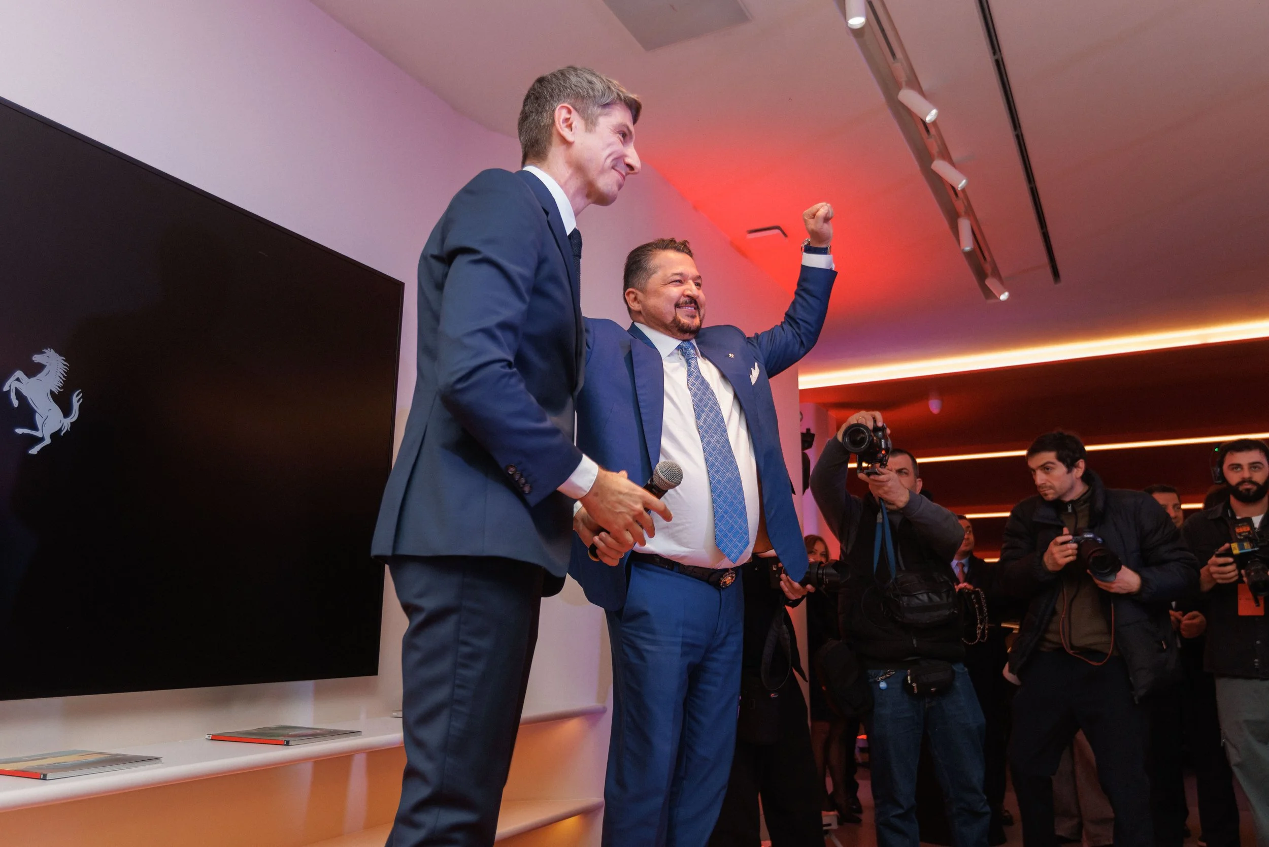 A luxury sports car parked in front of a modern, futuristic white building with curved, flowing architecture.