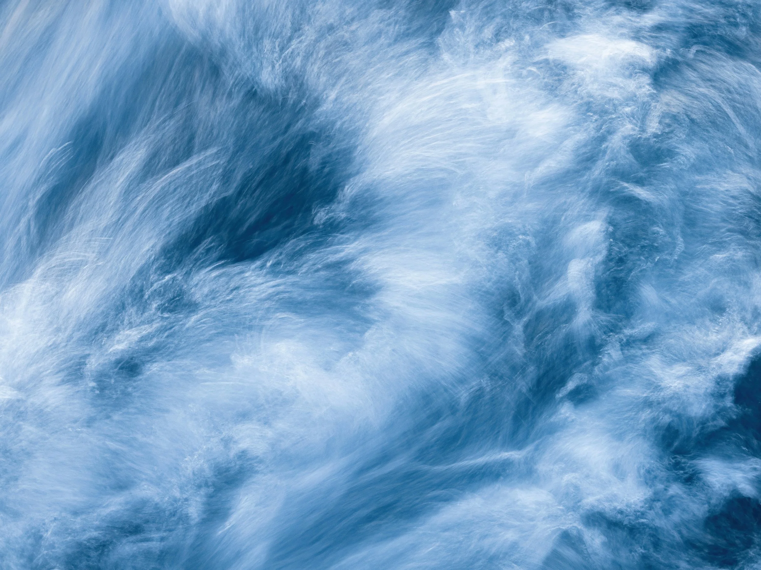 Abstract photo image of swirling water in shades of deep blue and white