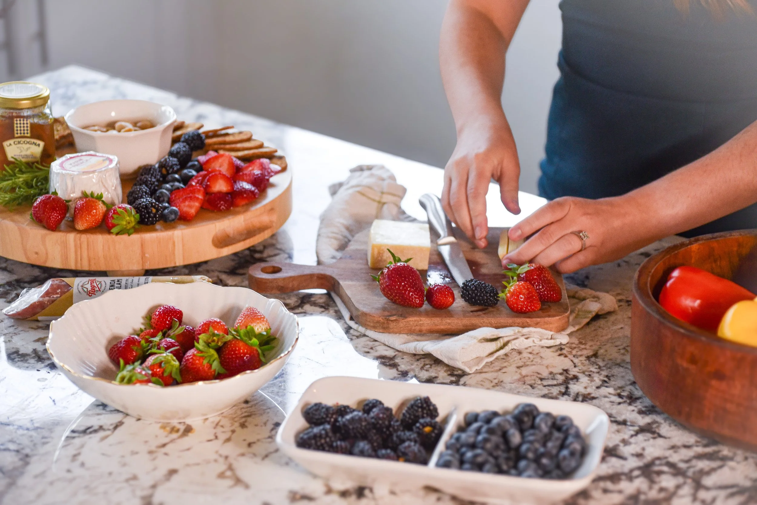 A person arranging fruit on a cutting board