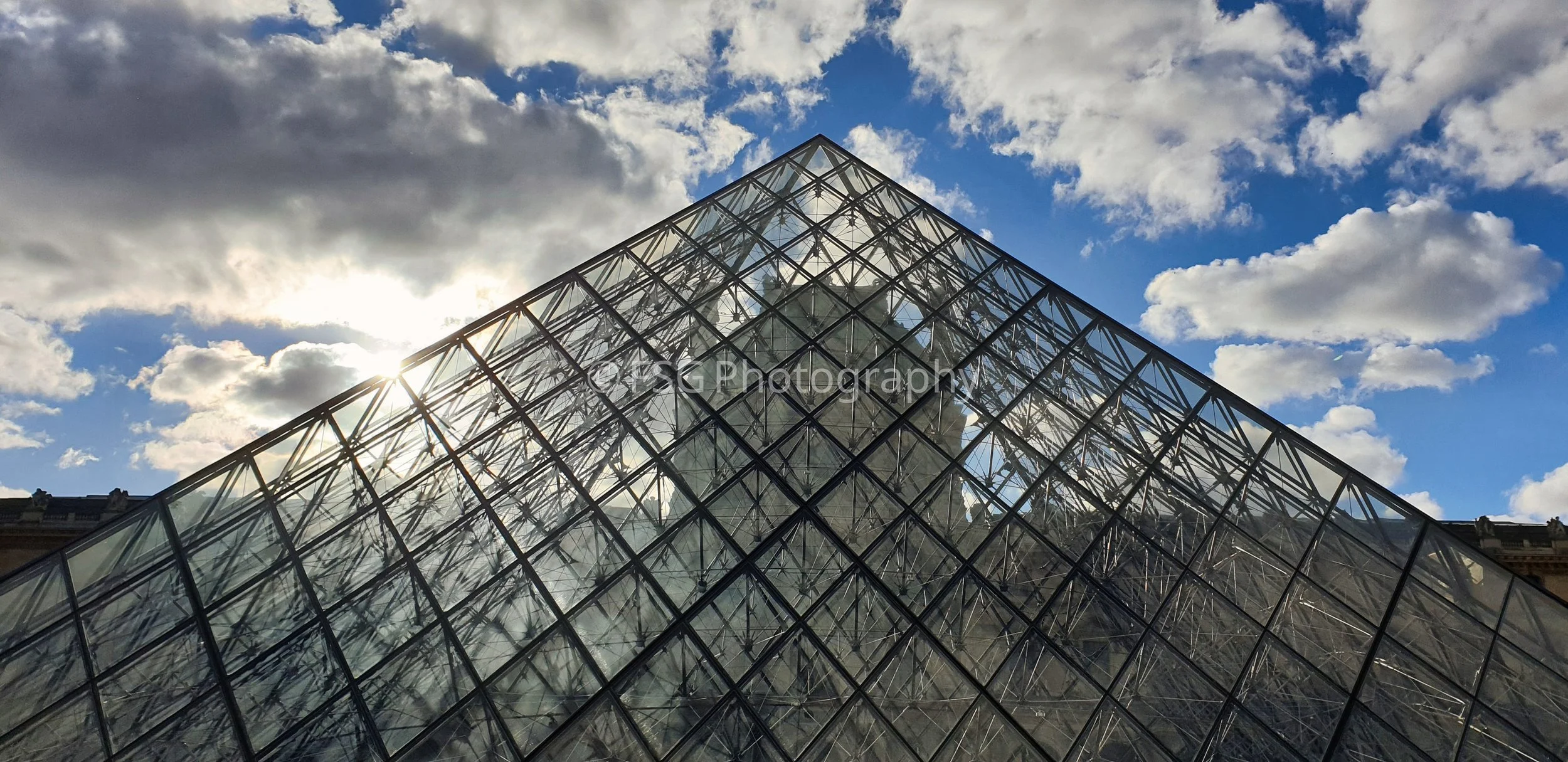 Fractured Sky

Captured from a striking upward angle, this photograph highlights the iconic glass structure designed by I.M. Pei against a dynamic Parisian sky.