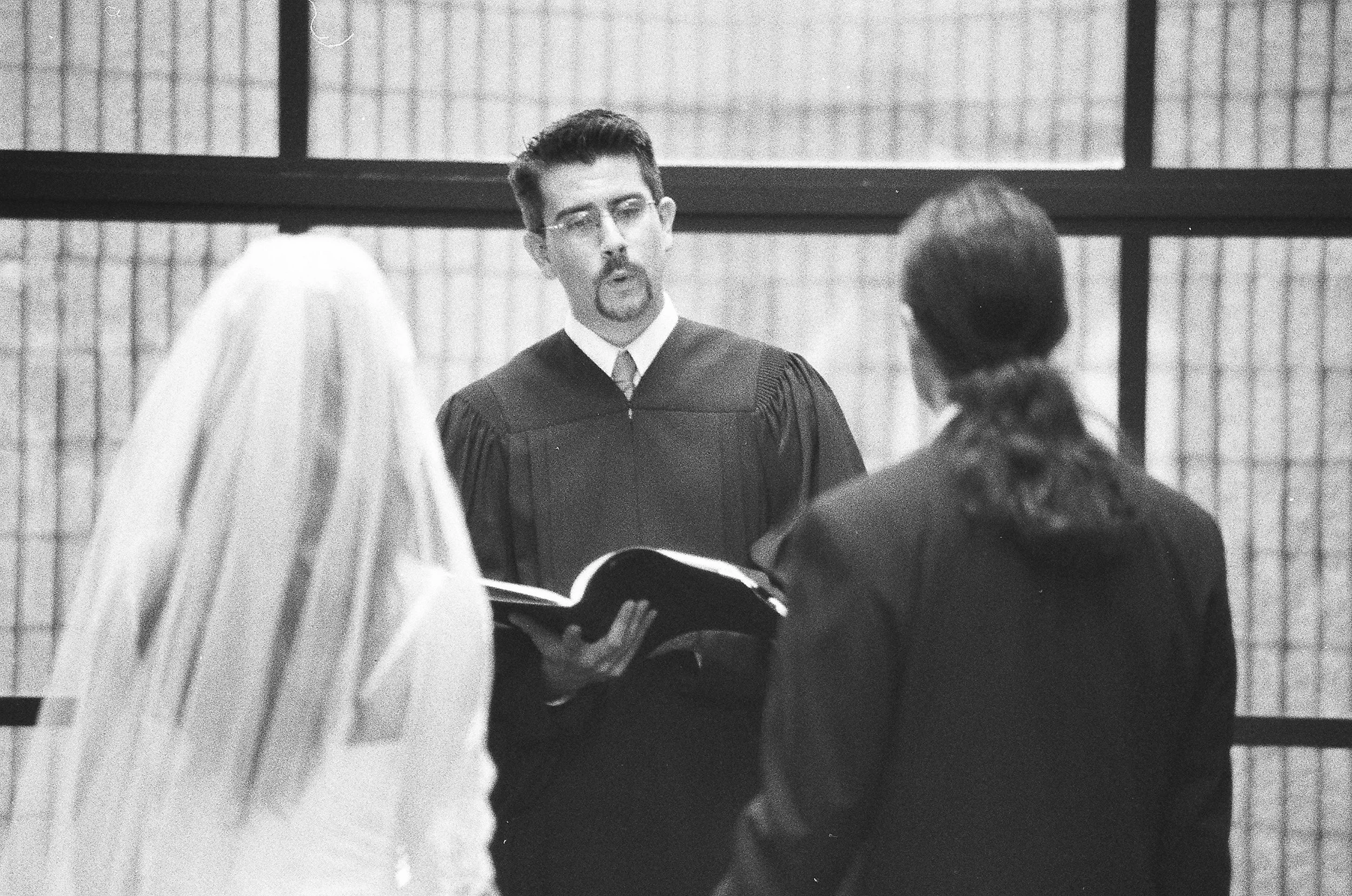 Pastor Danny marrying a couple in black in white
