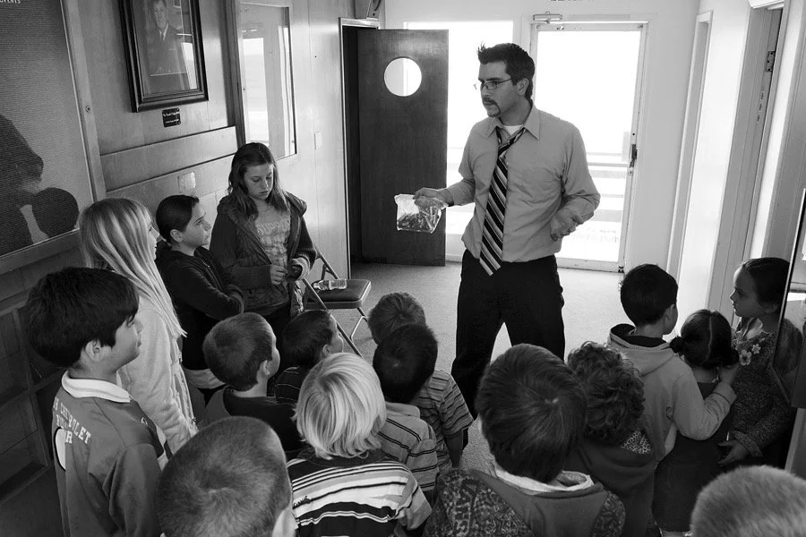 Pastor Danny asking questions and answers of children in black and white