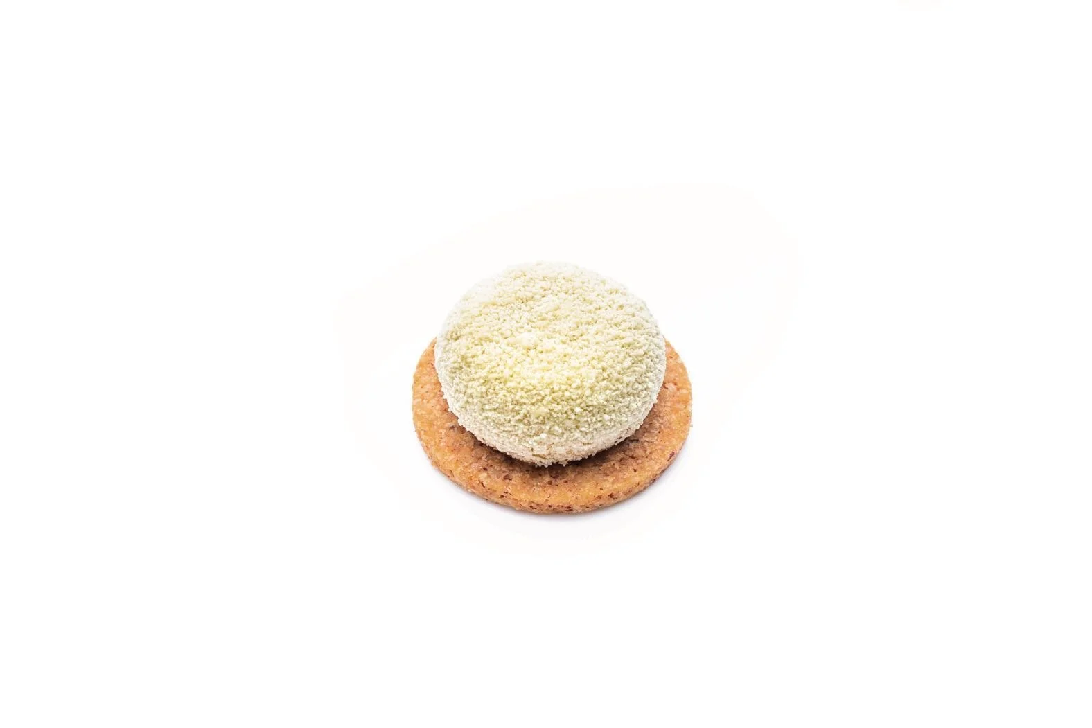 Crème brûlée cake with a white coconut style finish on a round biscuit base, photographed on a white background