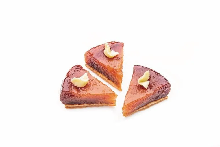 Three caramelized mini apple tatin tart slices on a golden shortbread base