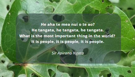 A quote attributed to Sir Apirana Ngata is overlaid on a background of green leaves, with a semi-transparent dark overlay behind the text.