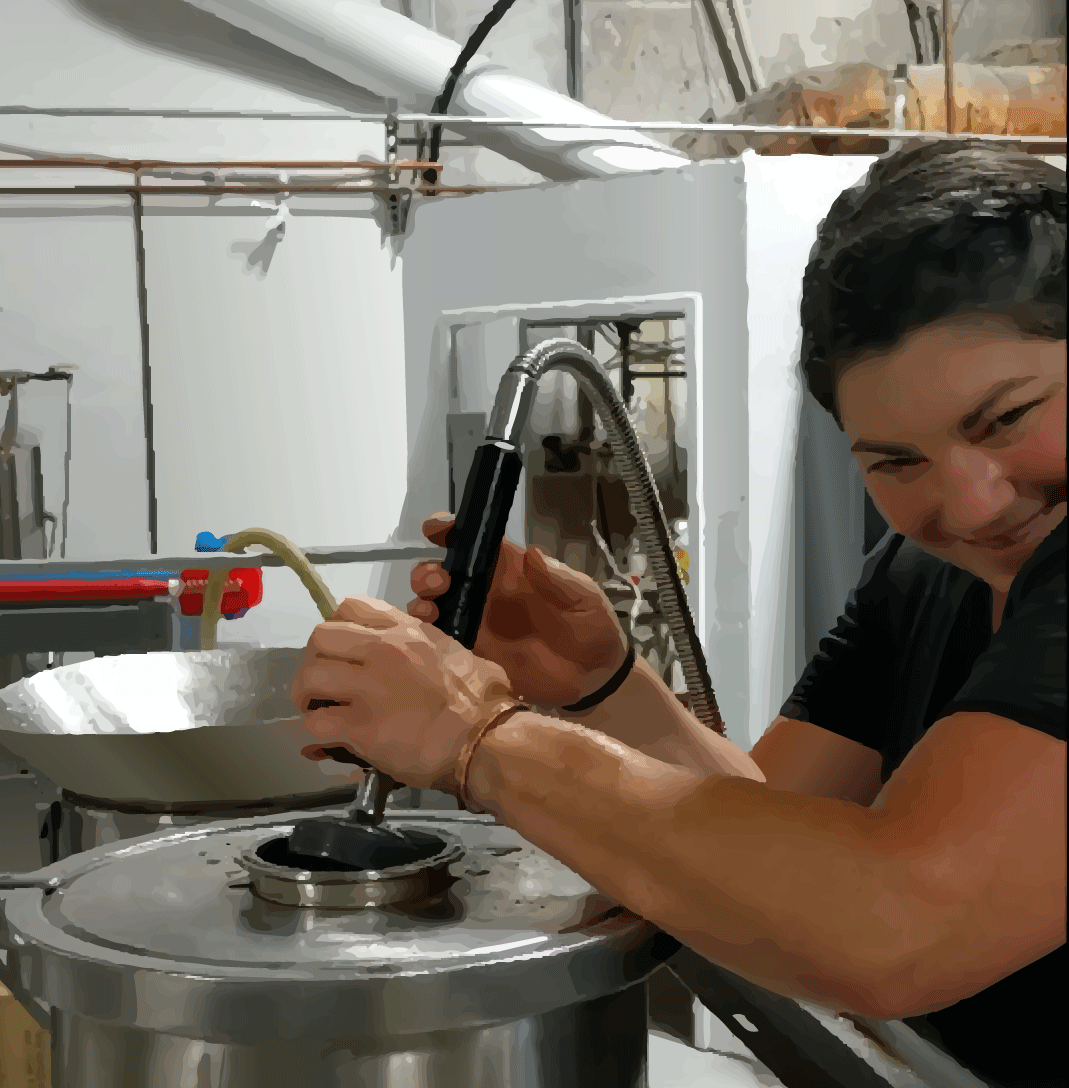 A person holding a kitchen tool and steaming an object in a cooking pot.