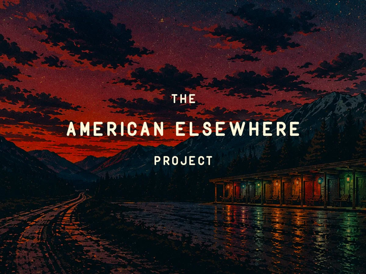 A stylized digital illustration of a mountain landscape at sunset or dusk with dark clouds in the sky, a train station with lit-up colorful lights, and a winding railroad track. The text "The American Elsewhere Project" is overlaid on the image.