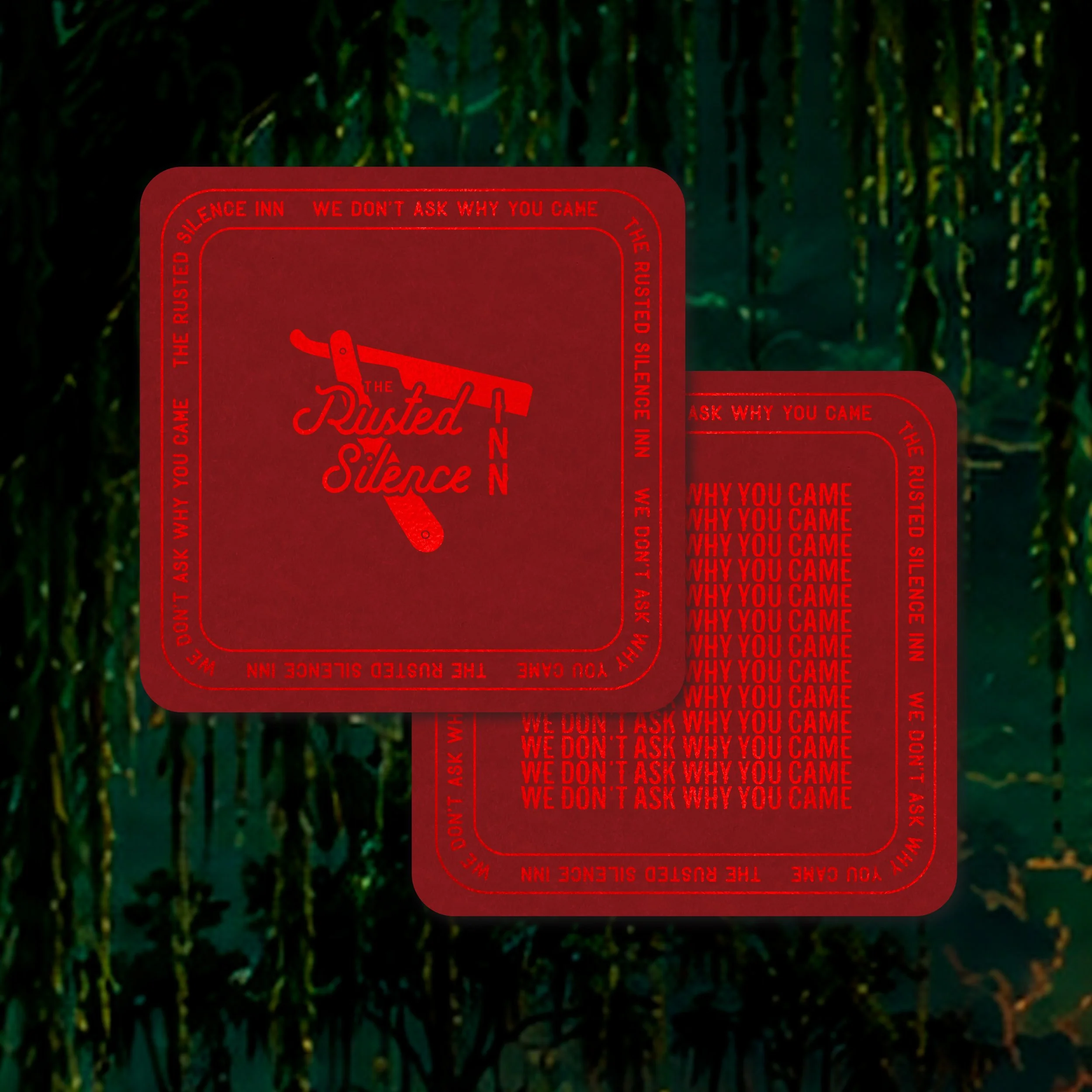 Close-up of a red sticker with the phrase 'The Ruined Silence' and various questions and statements written around it, placed on a dark green planting background.