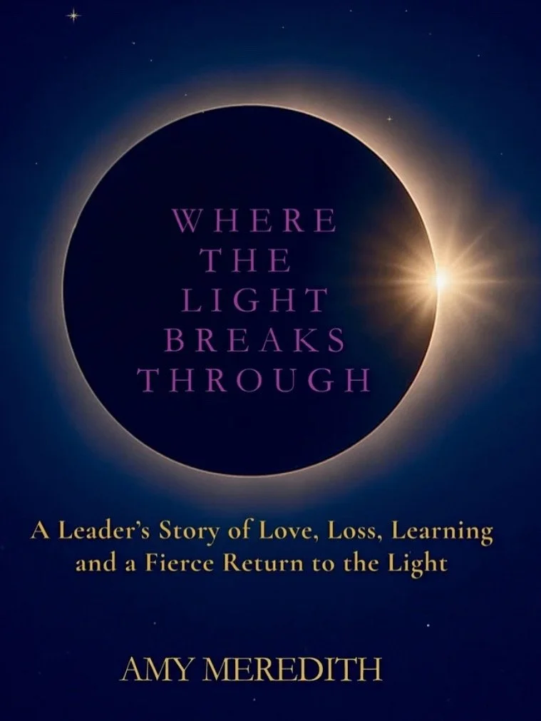 Book cover titled 'Where the Light Breaks Through' with a solar eclipse and stars in the background, subtitle 'A Leader’s Story of Love, Loss, Learning and a Fierce Return to the Light,' author Amy Meredith.