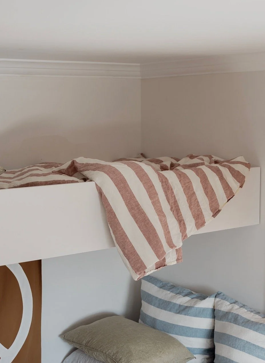 Cheerful striped bedlinen draped over top Single bunk