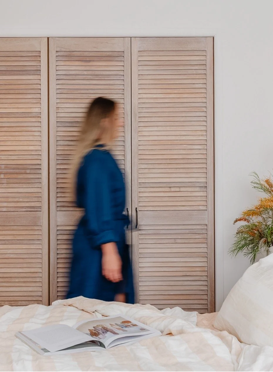 Female guest in robe in King bedroom walking in front of wardrobe 