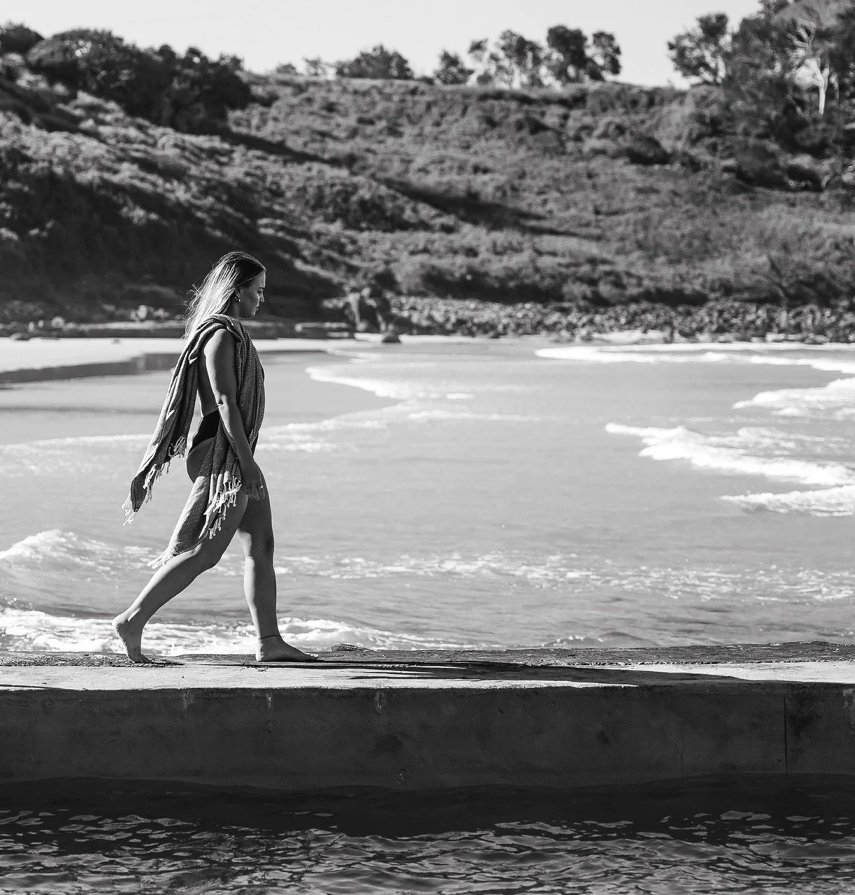 Female guest strolling along sea baths at Main Beach