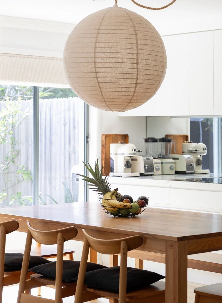 A bright sunny dining room with oversized round linen pendant