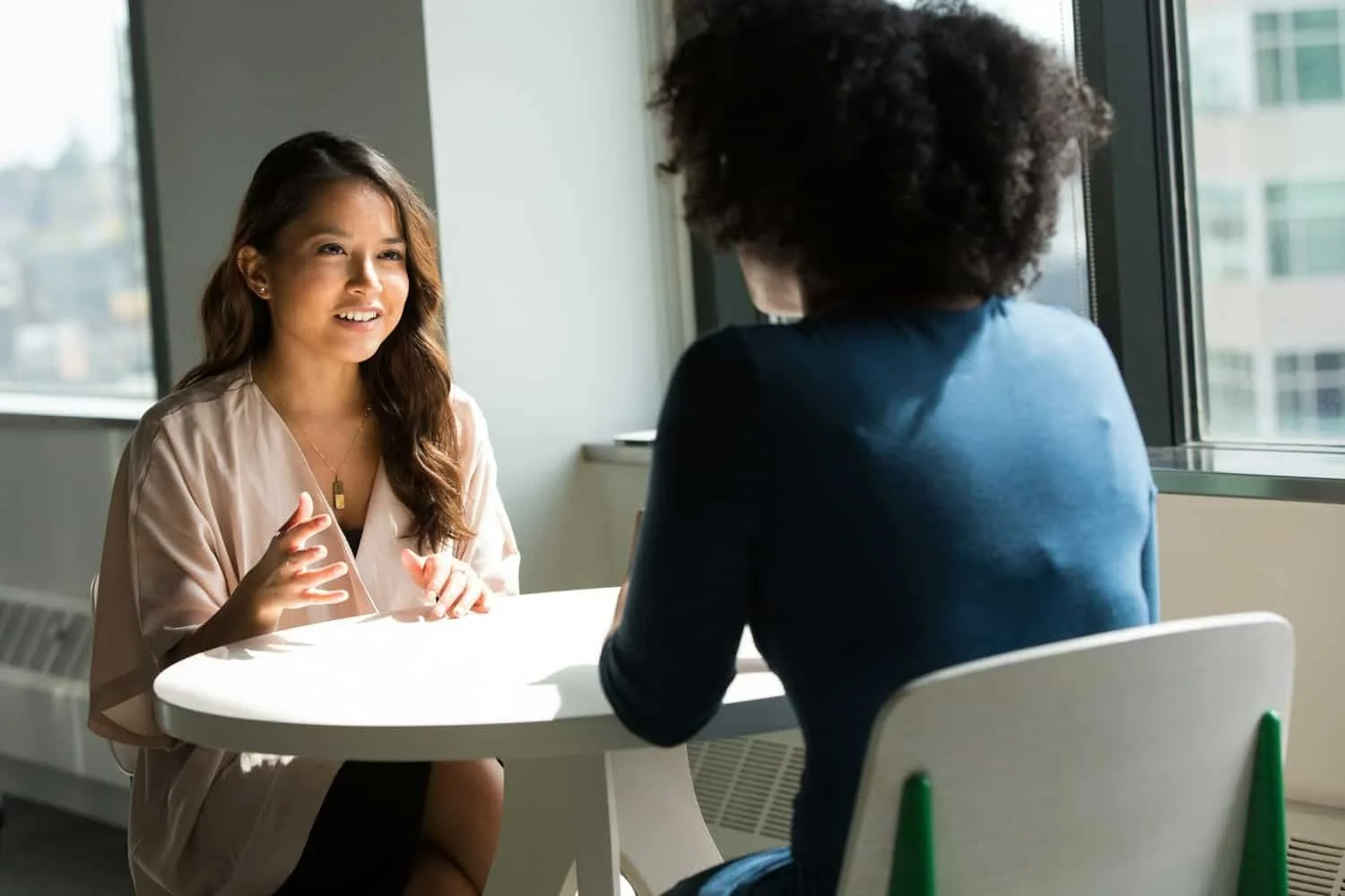 Two ladies sitting at a table having a conversation