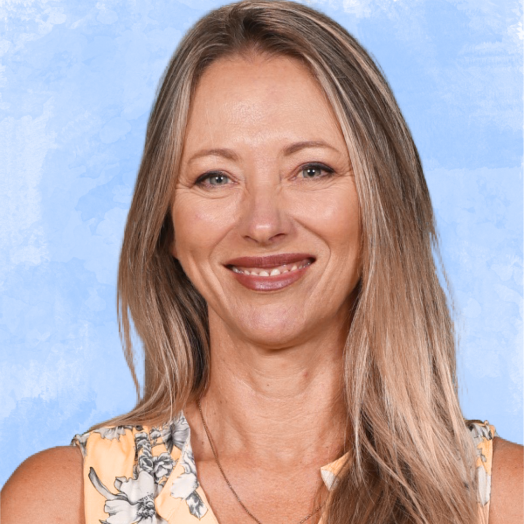 A portrait of a smiling woman with light brown hair, wearing a sleeveless floral top, against a blue textured background.
