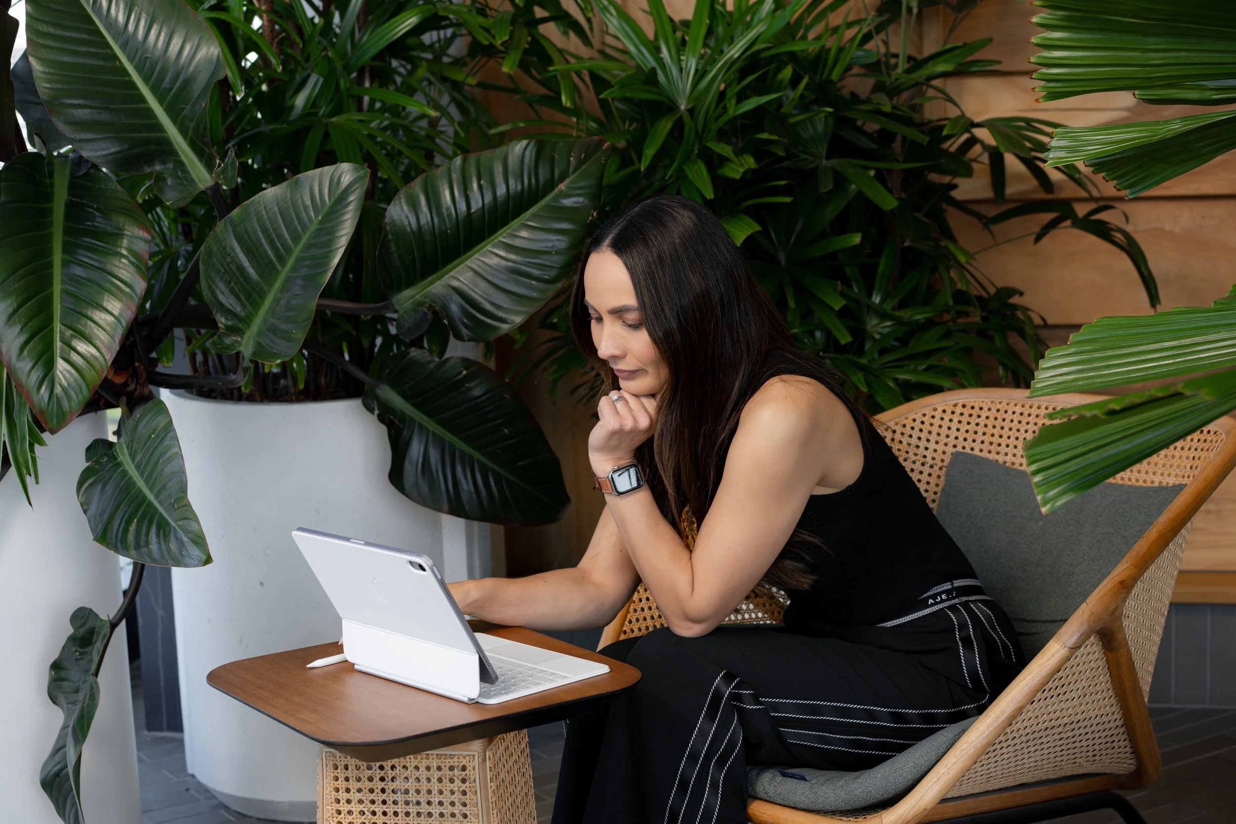 A woman doing a cat-cow yoga pose on a yoga mat indoors, with a wooden wall background.