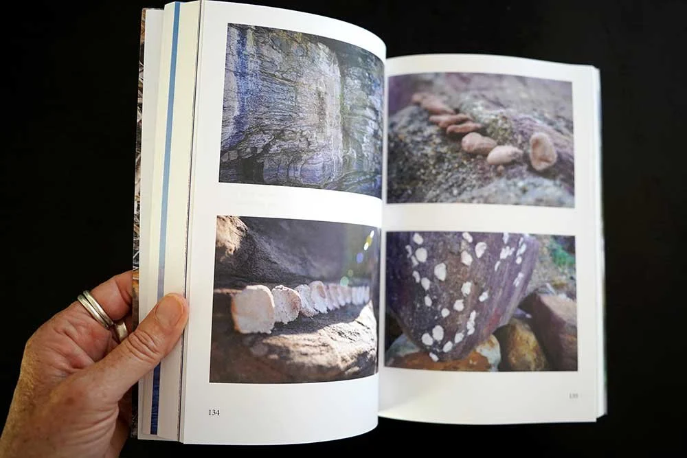Open book showing four photographs of rocks and stones, two on each page, with nature backgrounds.