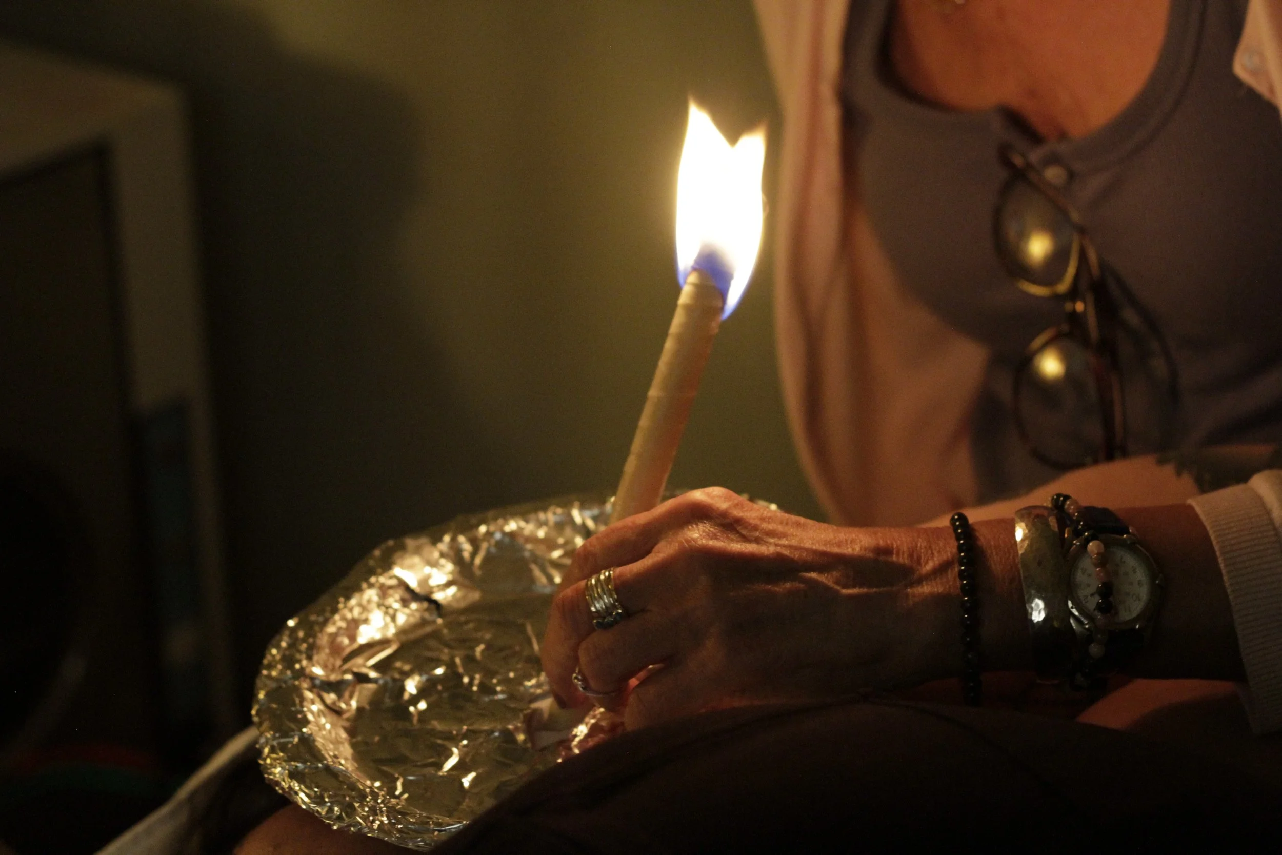 a lady performing an ear candling treatment