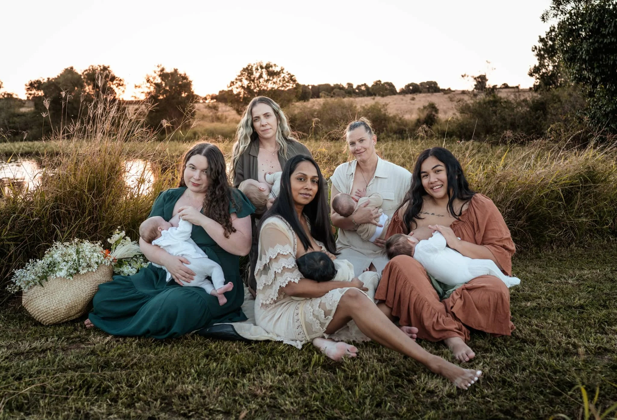 People sitting cross-legged on the floor holding hands during a meditation or group activity.