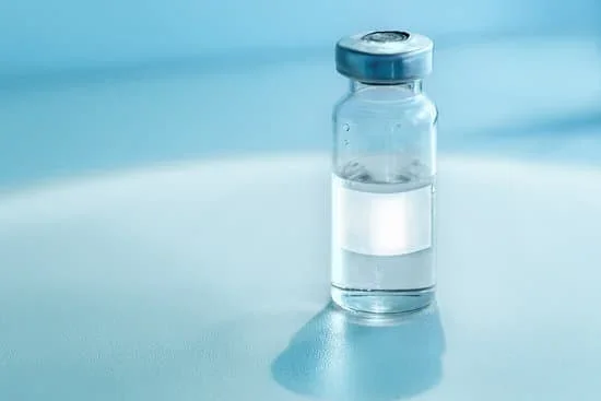 Glass vial filled with clear liquid next to a blue bottle and syringe, representing medication or lab testing