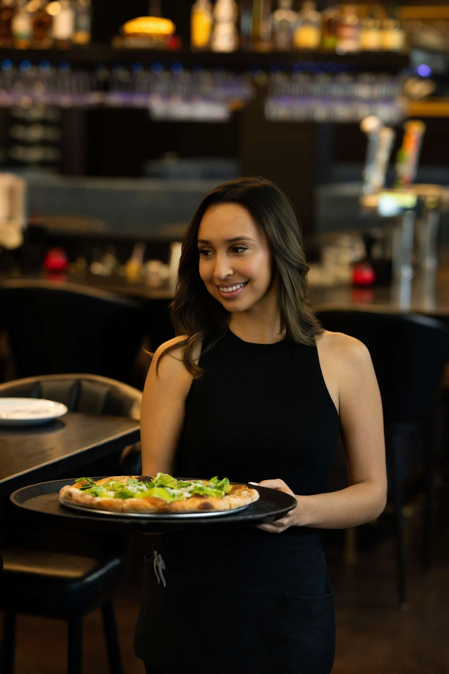 "Greens.
Parmesan.
A crust built with care.

Then the ritual begins.

A plate placed.
Light lowered.
A moment claimed.

It&rsquo;s never just pizza.

It&rsquo;s how it&rsquo;s served."