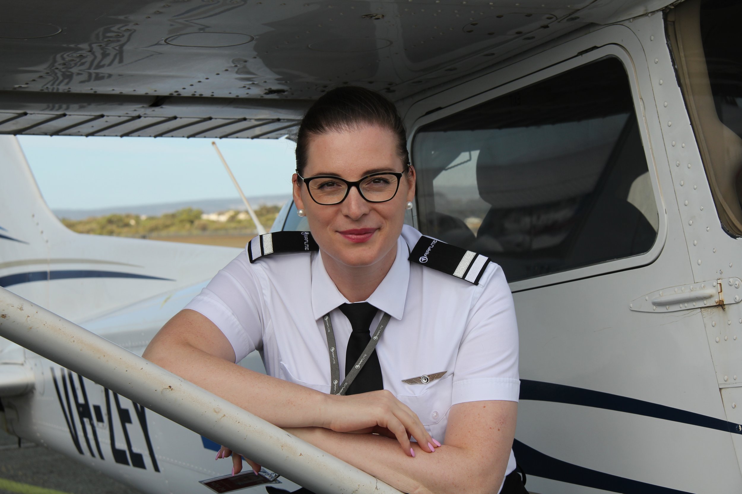 Female student pilot smiling in the cockpit of a training aircraft during flight training in Australia