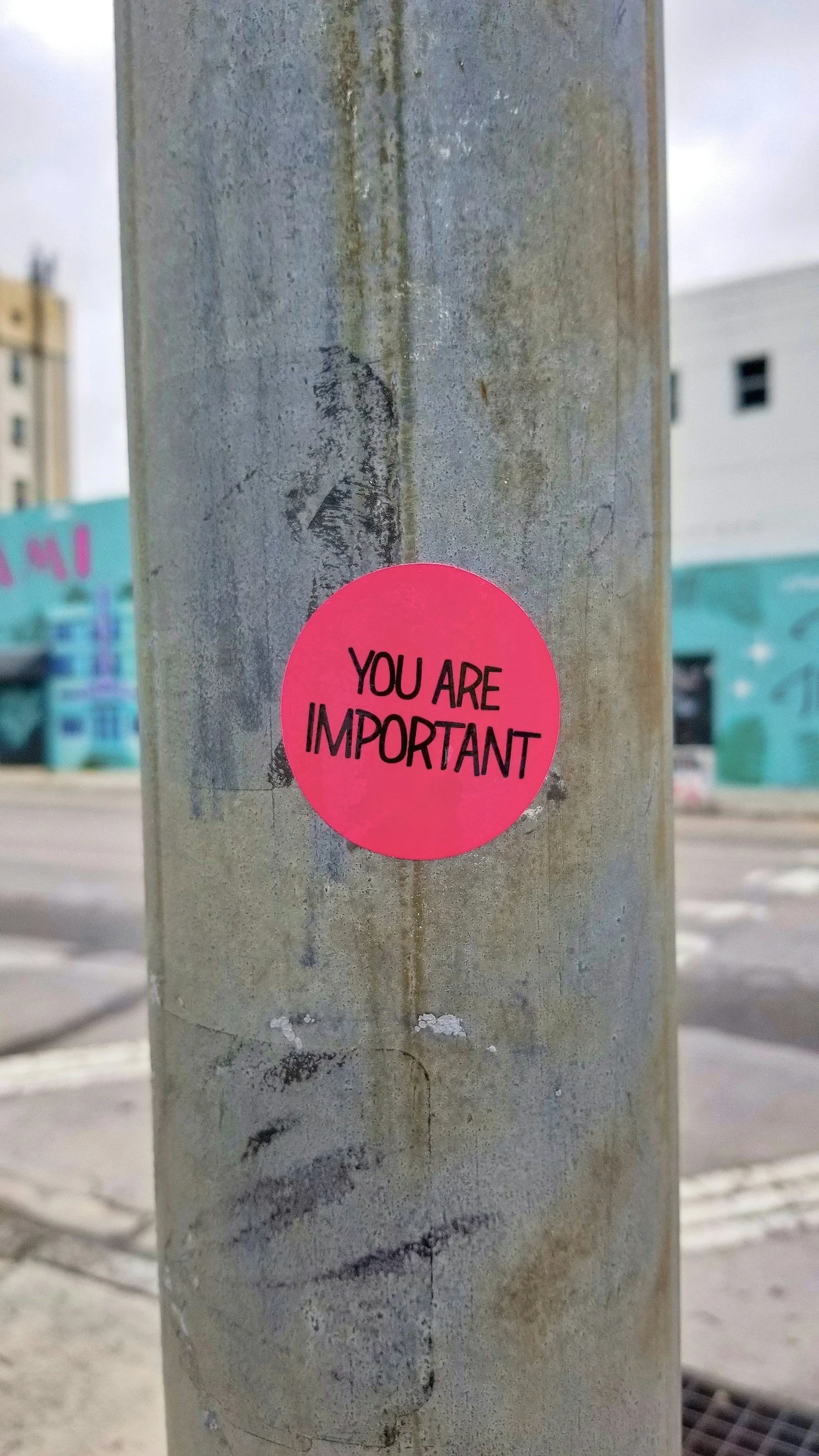 A pink sticker on a weathered metal pole that says "You Are Important."