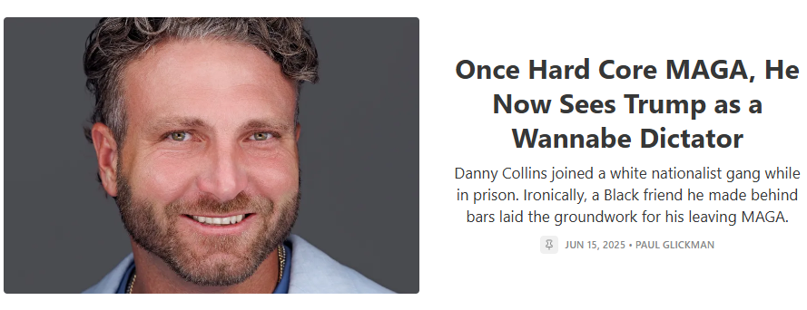 Close-up of a smiling man with curly hair and a beard, wearing a blue shirt.