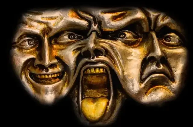 A dark-colored mask with three human faces merging together, showing different facial expressions including smiling, angry, and screaming.