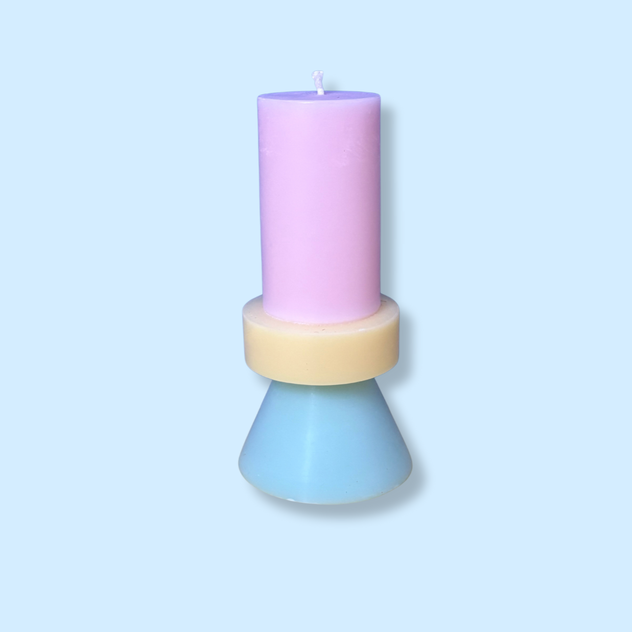 A pastel-coloured candle holder with a pink candle on top, a yellow ring in the middle, and a blue cone-shaped base, on a light blue background.
