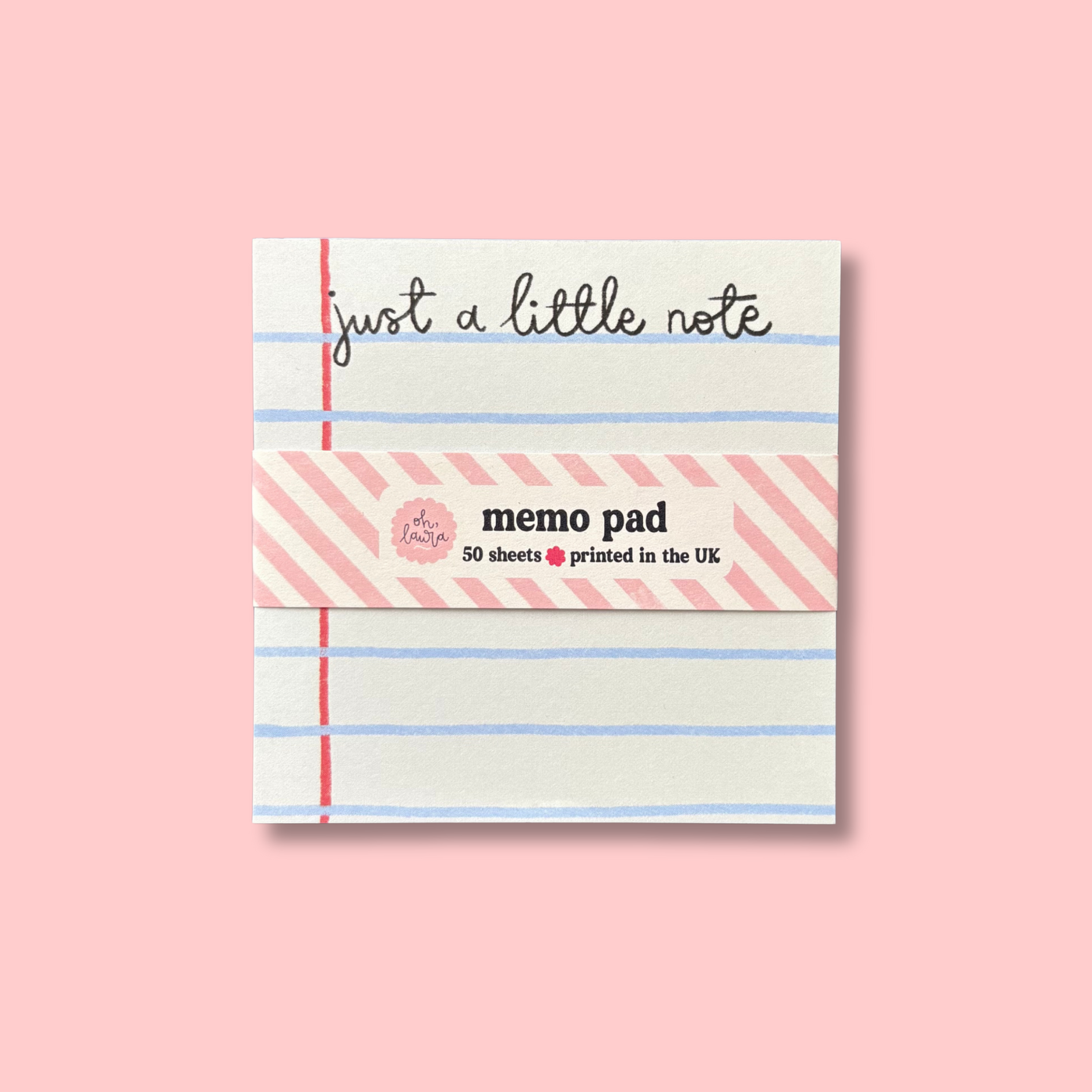 A pink memo pad with blue lines, the words 'just a little note' written at the top, and a label indicating it contains 50 sheets printed in the UK.