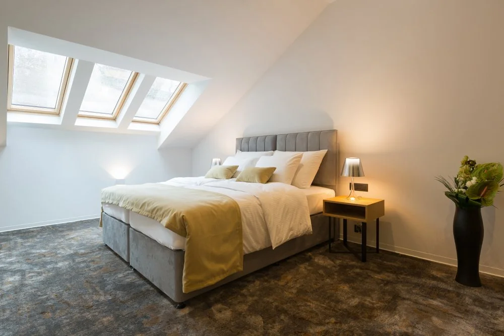 Loft conversion bedroom with fitted furniture and skylights in Swansea